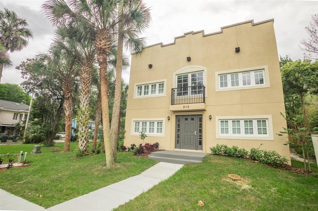 A two-story tan building with a central balcony and a gray front door — 915 E PALMETTO STREET, LAKELAND, FL