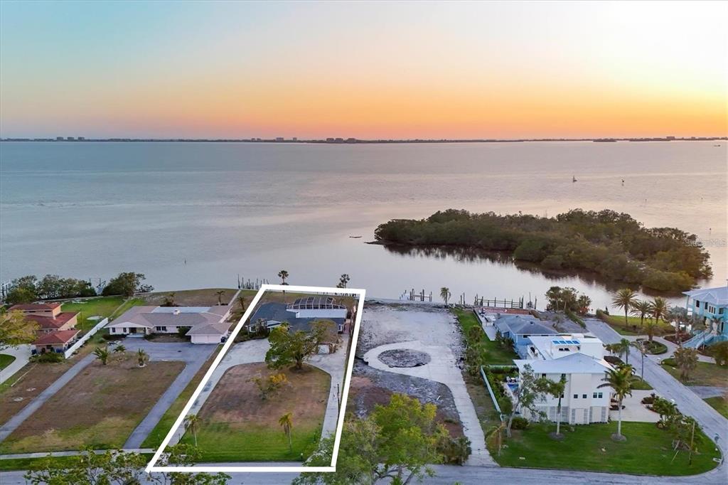An aerial view shows a waterfront property with a house and a large vacant lot — 7318 WESTMORELAND DRIVE, SARASOTA, FL