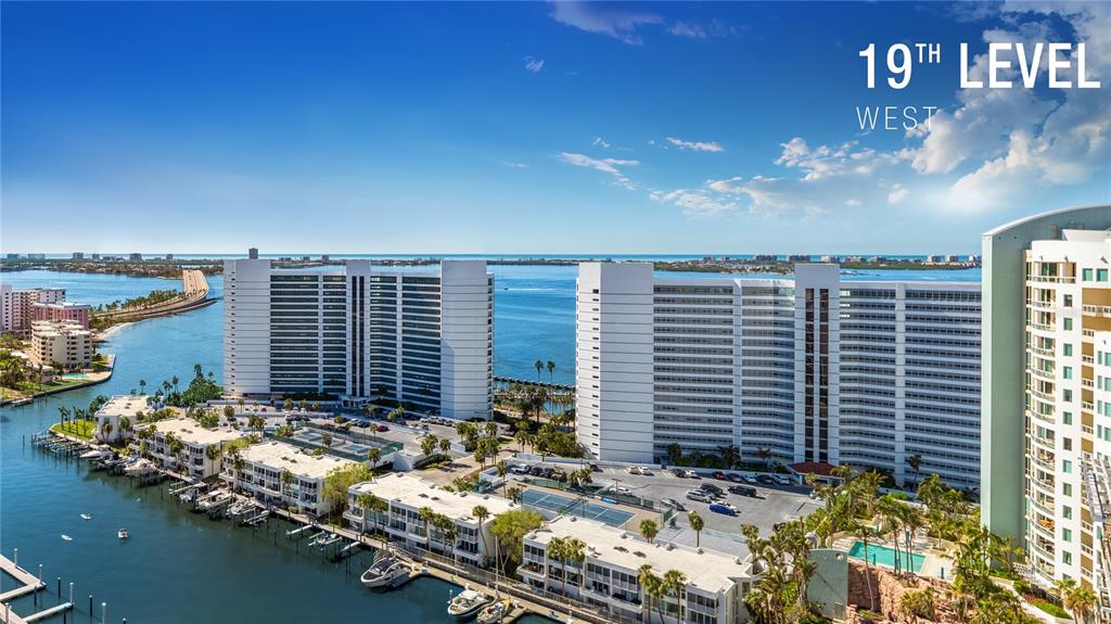 This is a digital architectural rendering of a modern high-rise apartment building at dusk — 1000 BOULEVARD OF THE ARTS UNIT 1806, SARASOTA, FL