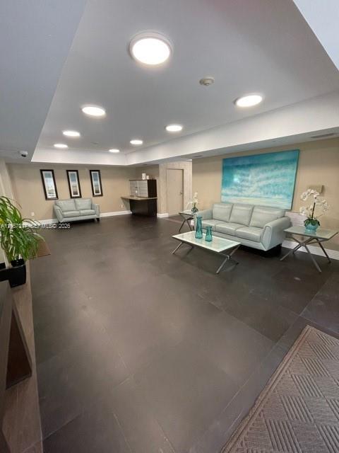 A spacious lobby features light-colored sofas, dark tile flooring, and a large abstract wall painting — 2650 SW 37th Ave # 501, Miami FL 33133, MIAMI, FL
