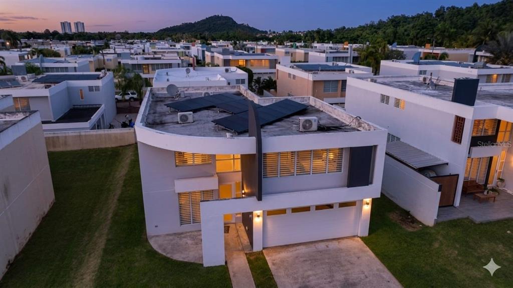 An aerial view of a modern two-story house with solar panels on the flat roof — Calle Isleña HACIENDA PALOMA, LUQUILLO, PR