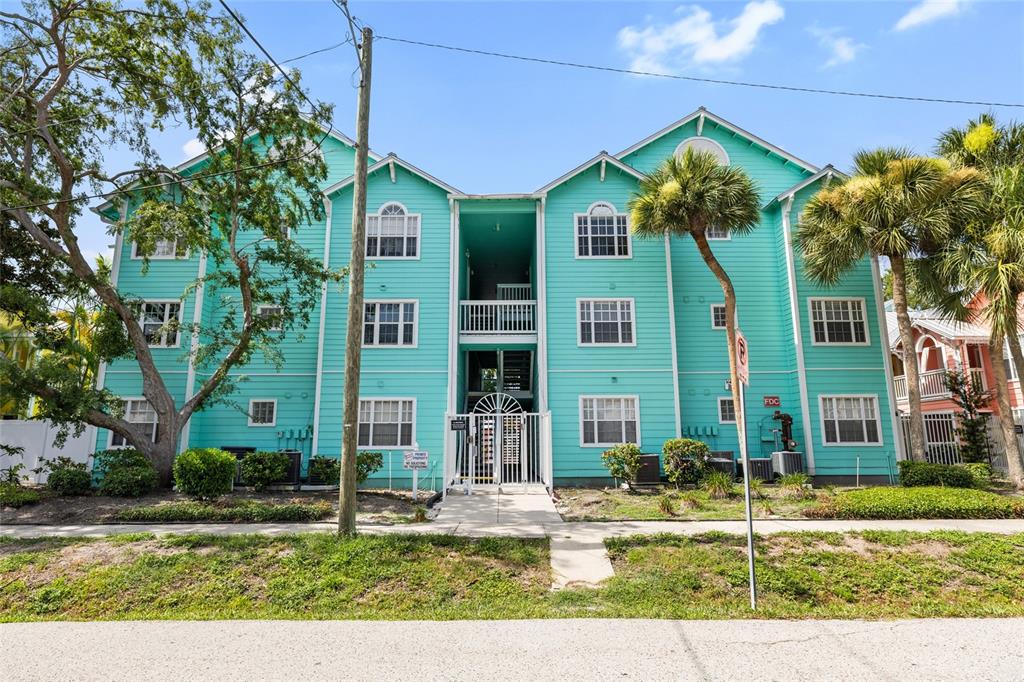 A turquoise door with a wreath opens onto a covered wooden deck with stairs — 3002 W CLEVELAND STREET UNIT B6, TAMPA, FL