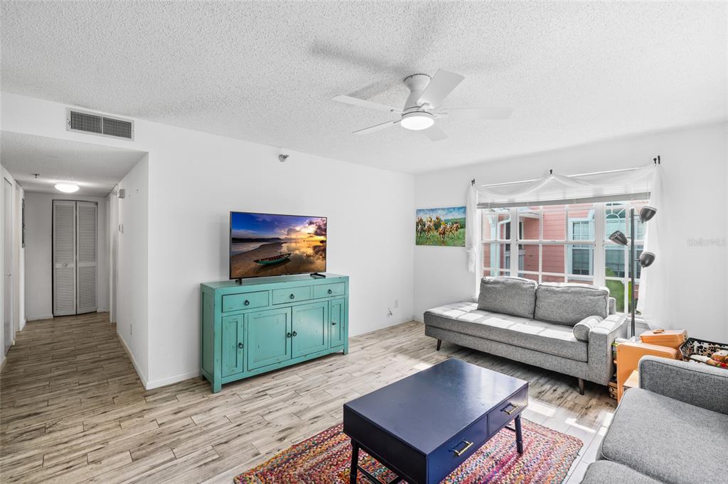 A living room features a teal console, a gray sofa, and a blue coffee table — 3002 W CLEVELAND STREET UNIT B6, TAMPA, FL