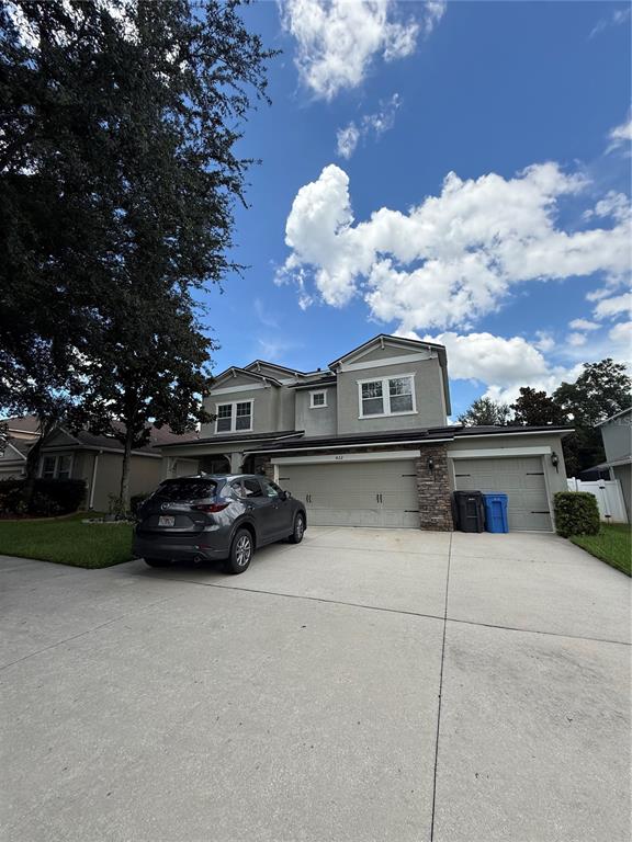 A two-story house with a gray exterior, a three-car garage, and a parked SUV — 422 WESTCHESTER HILLS LANE, VALRICO, FL