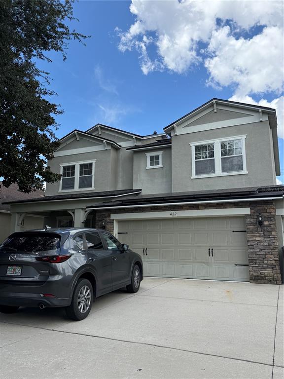 A two-story house with a gray stucco exterior, stone accents, and a two-car garage — 422 WESTCHESTER HILLS LANE, VALRICO, FL