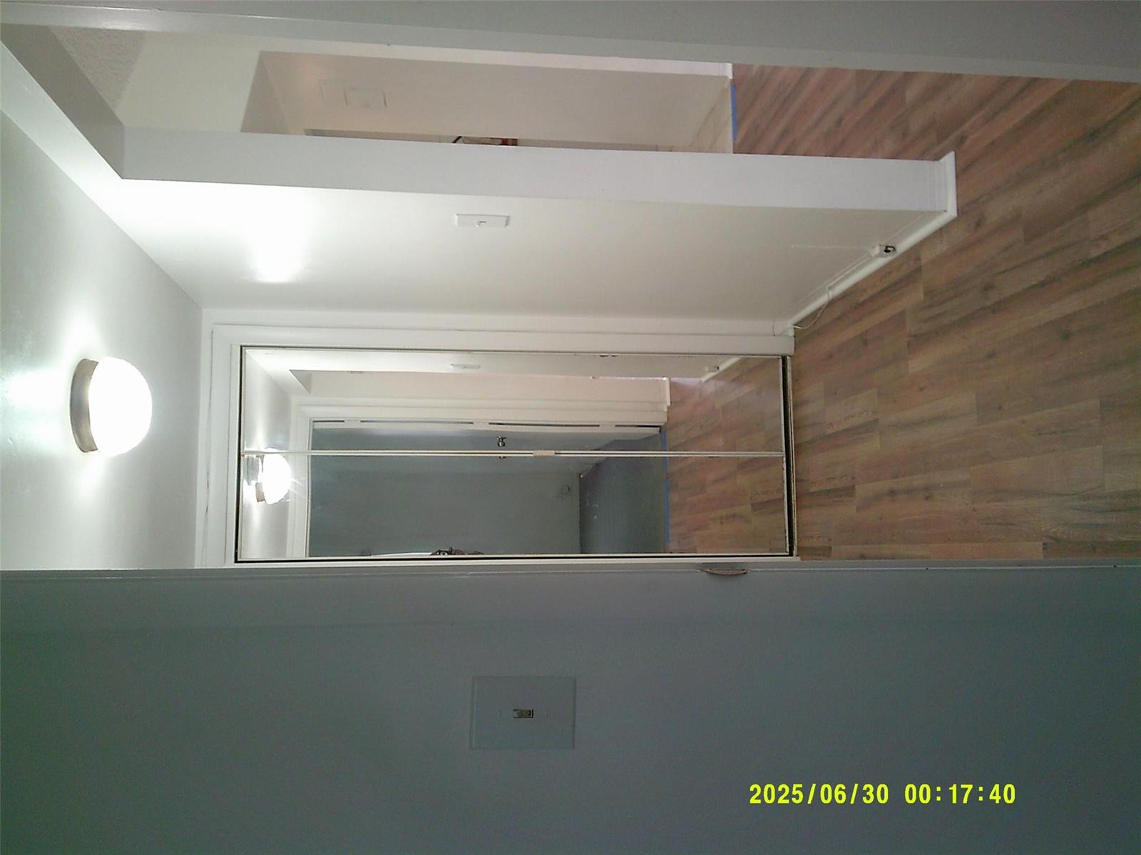 A hallway features wood-look flooring, a wall-mounted light fixture, and mirrored closet doors — 5800 Margate Boulevard # 4, Margate FL 33063, MARGATE, FL