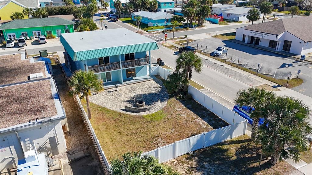 An aerial view shows a two-story blue building with a fenced yard and patio — 212 S DAYTONA AVENUE UNIT 1, FLAGLER BEACH, FL