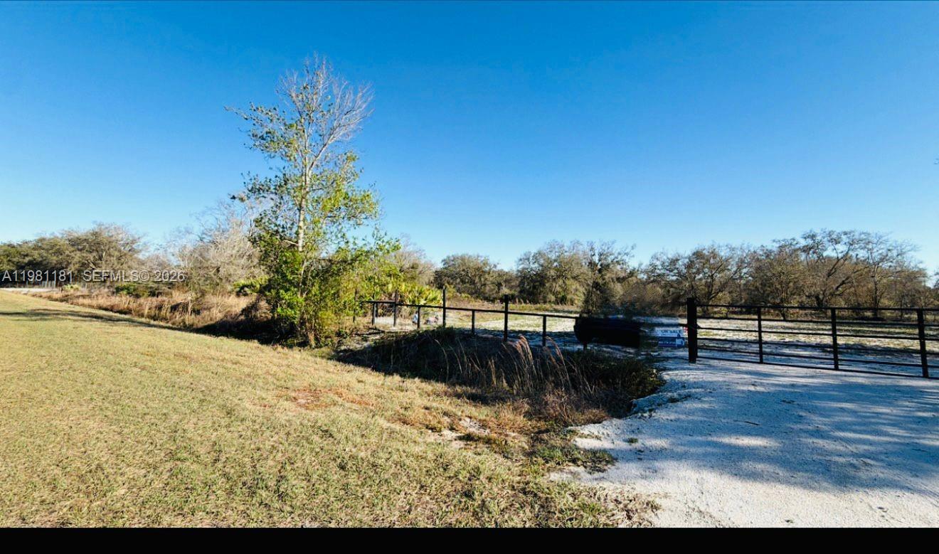 A dirt driveway leads to a gated entrance of a large, grassy, undeveloped rural lot — 18626 NW 284 st, Okeechobee FL 34972, OKEECHOBEE, FL