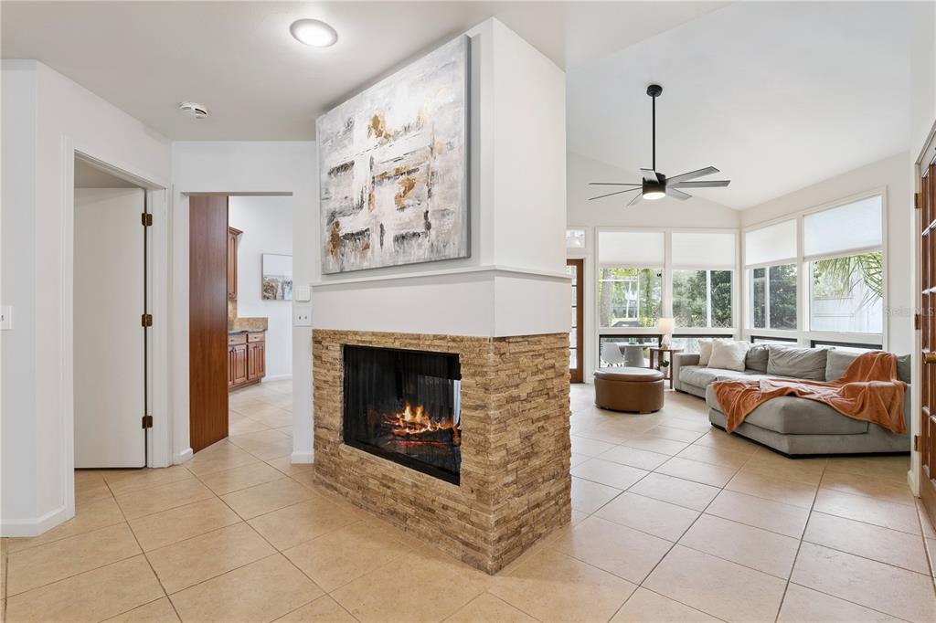 A living room features a stone fireplace, tile flooring, and a large abstract painting — 2538 LONG IRON COURT, LONGWOOD, FL
