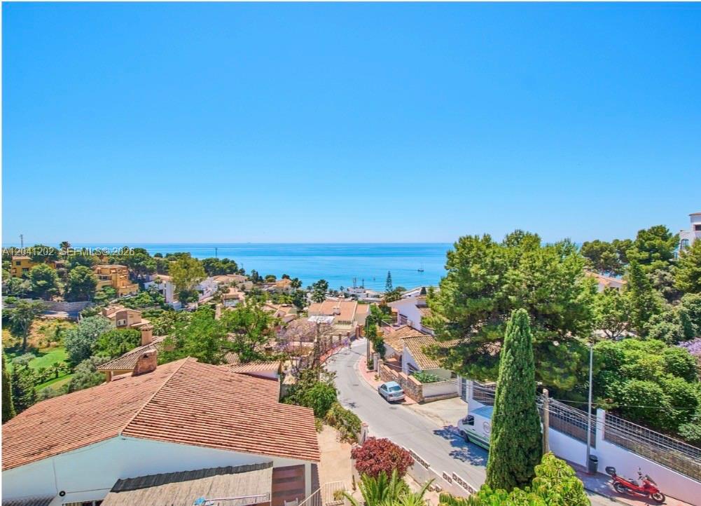 An elevated view of a coastal neighborhood with houses, a winding road, and the sea — 29018 MALAGA, ESPAIN, FL