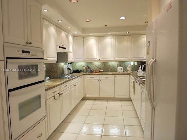 A kitchen features white cabinets, light-colored countertops, a double wall oven, and tiled flooring — 201 Crandon Blvd # 1027, Key Biscayne FL 33149, KEY BISCAYNE, FL