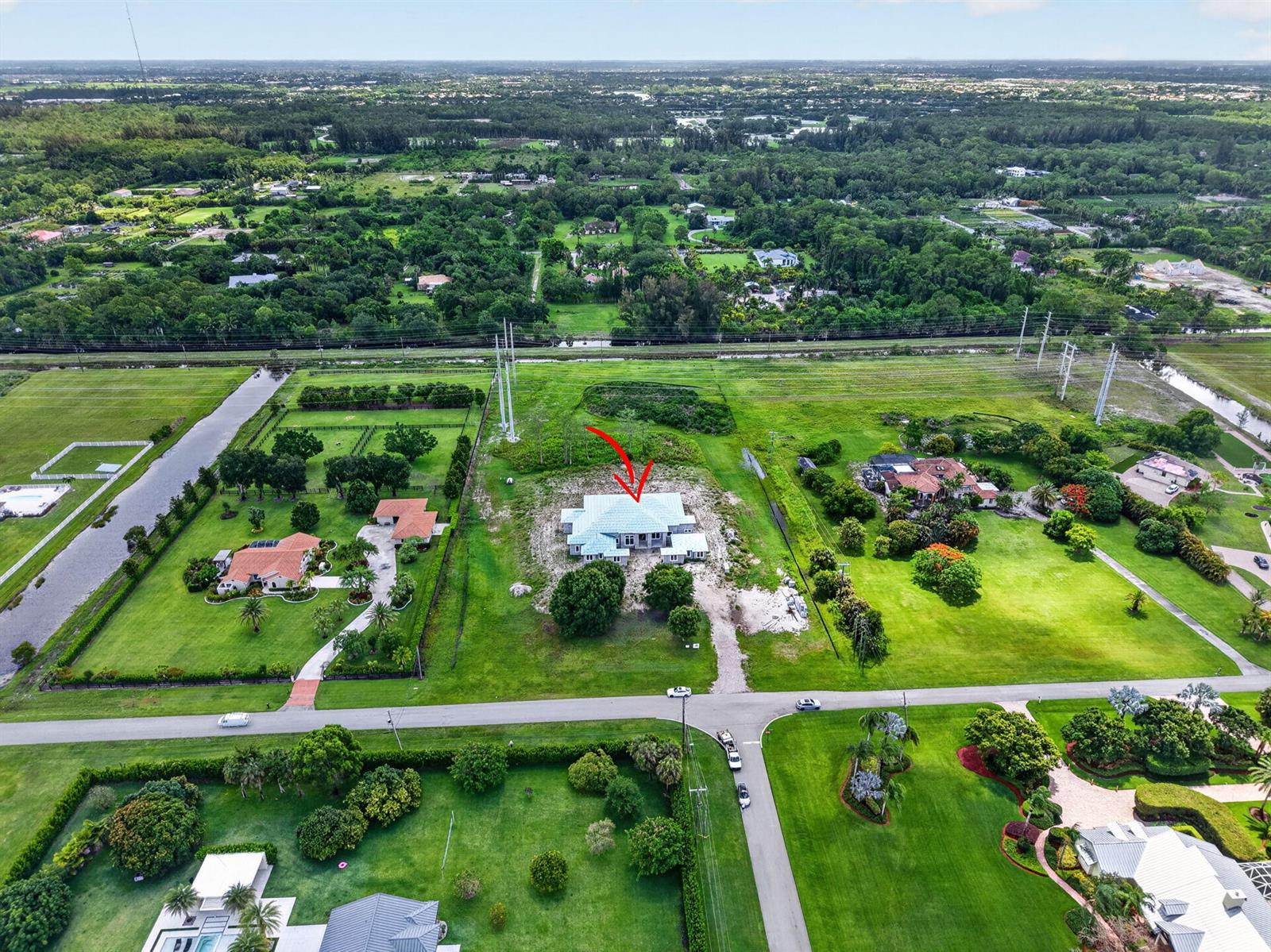 An aerial view shows a house under construction with a light-colored roof on a large lot — 6450 Sugarcane Lane, Lake Worth FL 33449, LAKE WORTH, FL