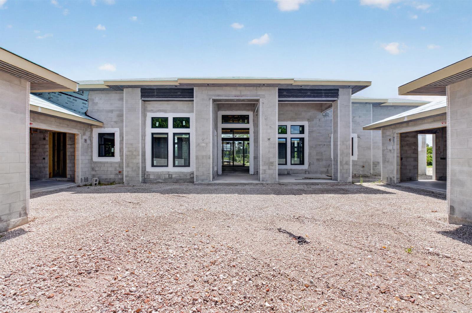 An exterior view of a concrete block house under construction with a gravel driveway — 6450 Sugarcane Lane, Lake Worth FL 33449, LAKE WORTH, FL
