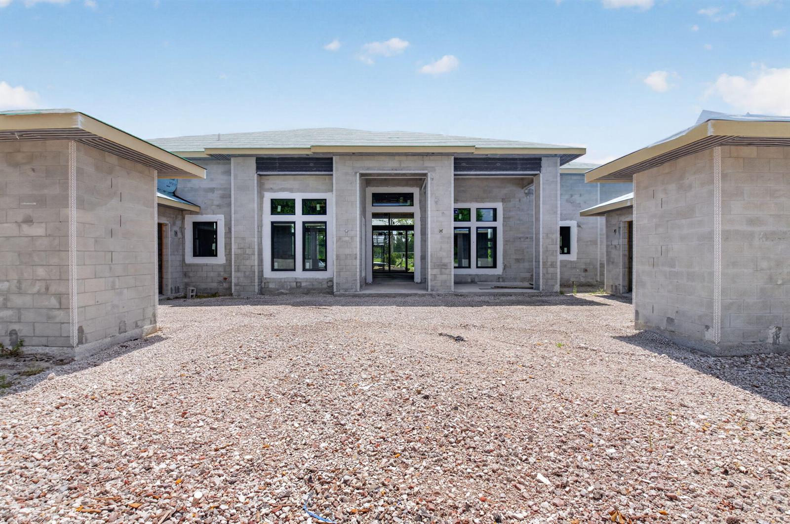 The exterior of a house under construction features concrete block walls and installed window frames — 6450 Sugarcane Lane, Lake Worth FL 33449, LAKE WORTH, FL