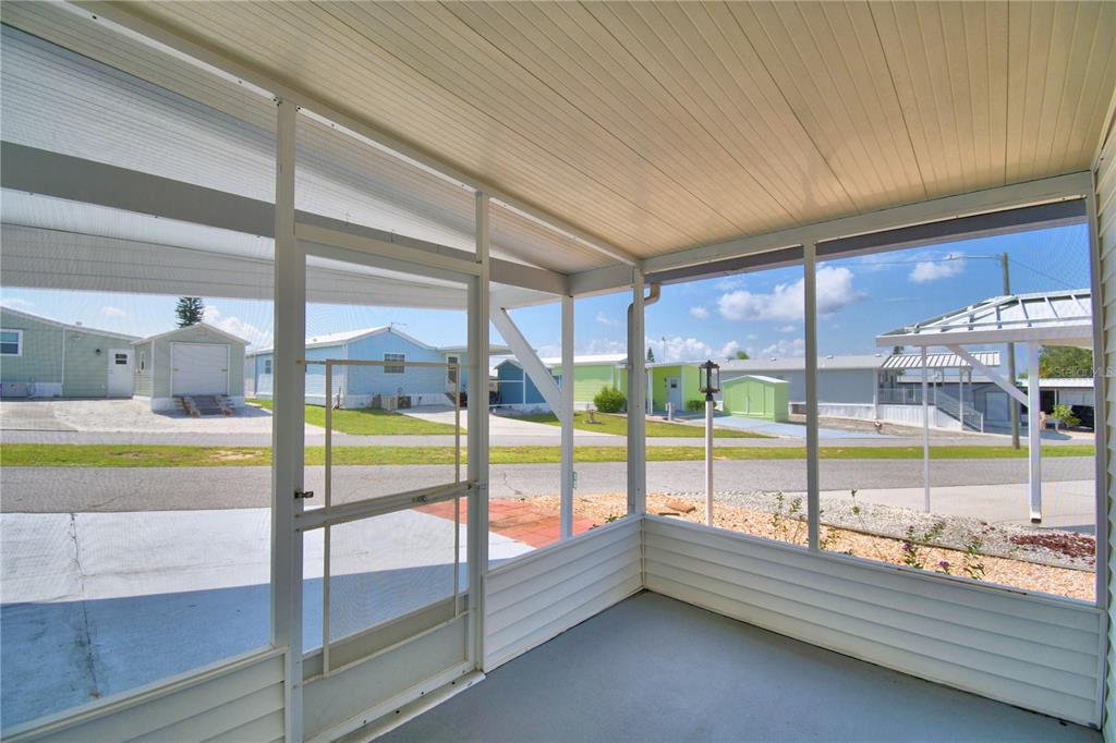 A screened-in porch overlooks a neighborhood of manufactured homes on a sunny day — 251 PATTERSON ROAD UNIT E12, HAINES CITY, FL