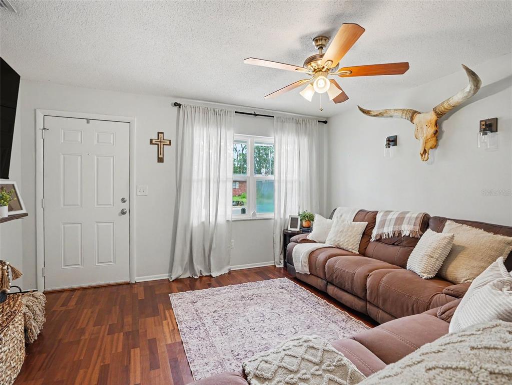 A kitchen and dining area with wooden cabinets, tile flooring, and a farmhouse-style table — 2804 KATHRYN AVENUE, LAKELAND, FL