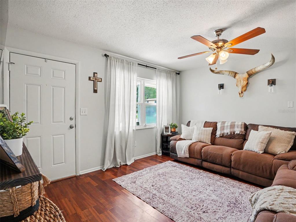 A kitchen with wood cabinets and tile floors opens to a backyard through sliding doors — 2804 KATHRYN AVENUE, LAKELAND, FL