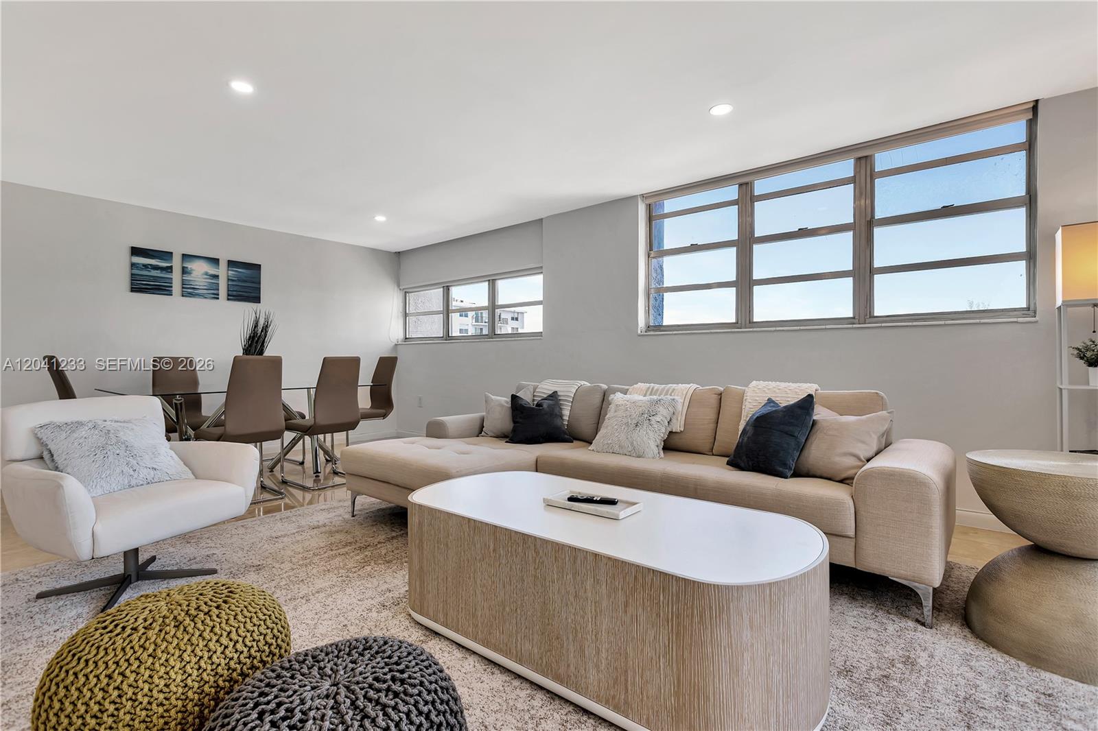 A living room features a beige sectional sofa, white armchair, and a dining area — 800 West Ave # 635, Miami Beach FL 33139, MIAMI BEACH, FL