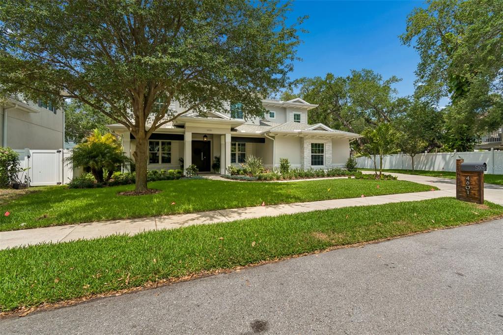 A two-story house with a light-colored exterior, a large front tree, and a paved driveway — 4601 S ESPERANZA AVENUE, TAMPA, FL