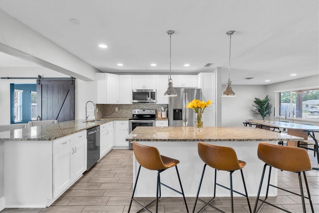 A dining room features a wooden oval table, black chairs, a large mirror, and area rug — 6860 14TH WAY S, ST PETERSBURG, FL