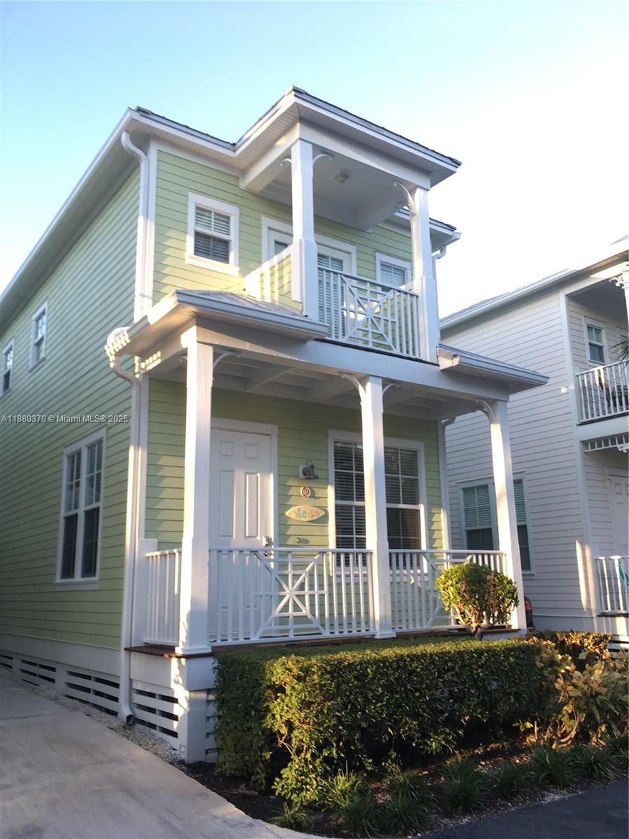 A two-story light green house features a front porch, a balcony, and white railings — 111 Anglers Way, Islamorada FL 33036, ISLAMORADA, FL