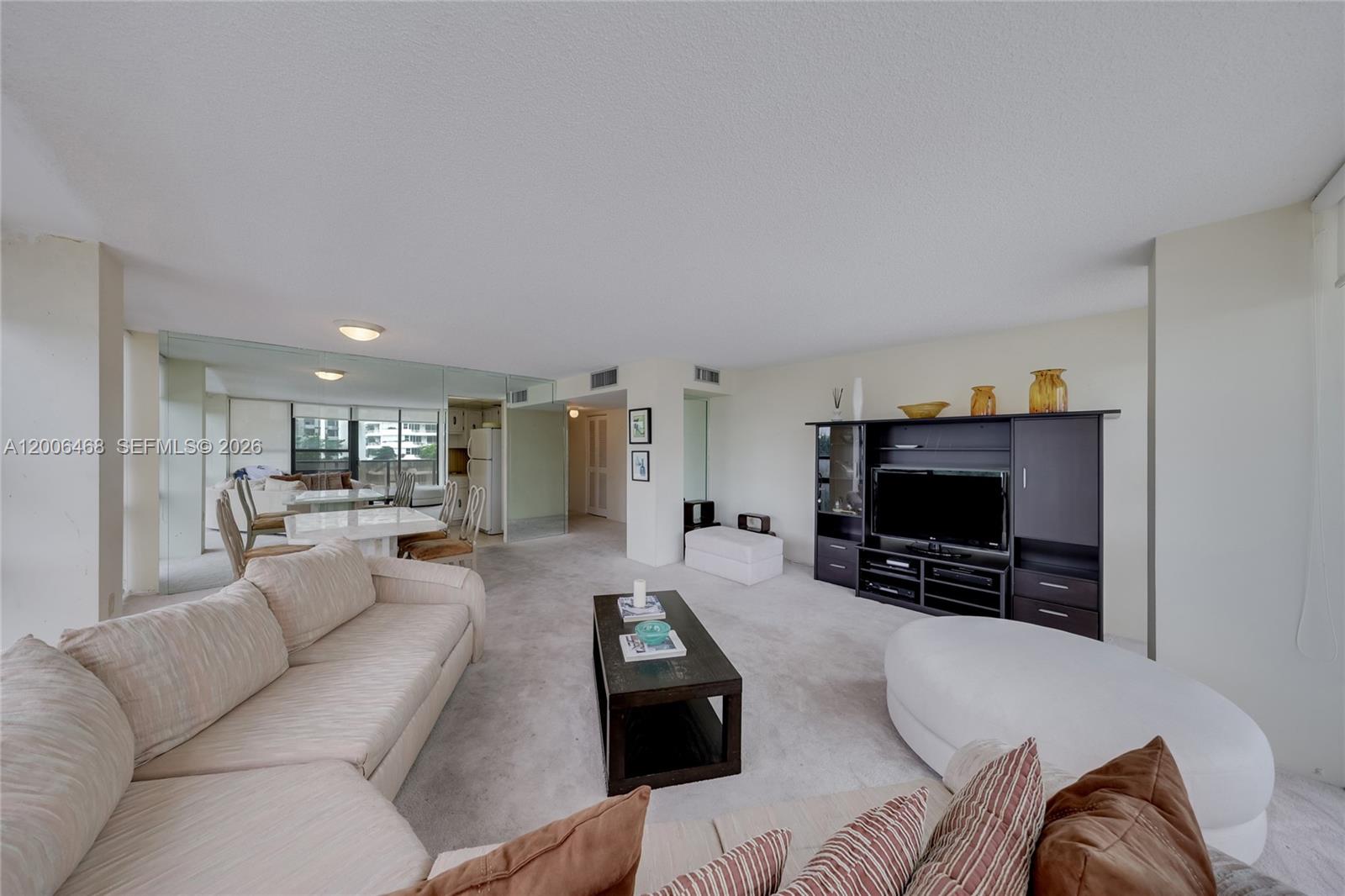 A living room features a sectional sofa, a dark coffee table, and a media console — 600 NE 36th St # 421, Miami FL 33137, MIAMI, FL