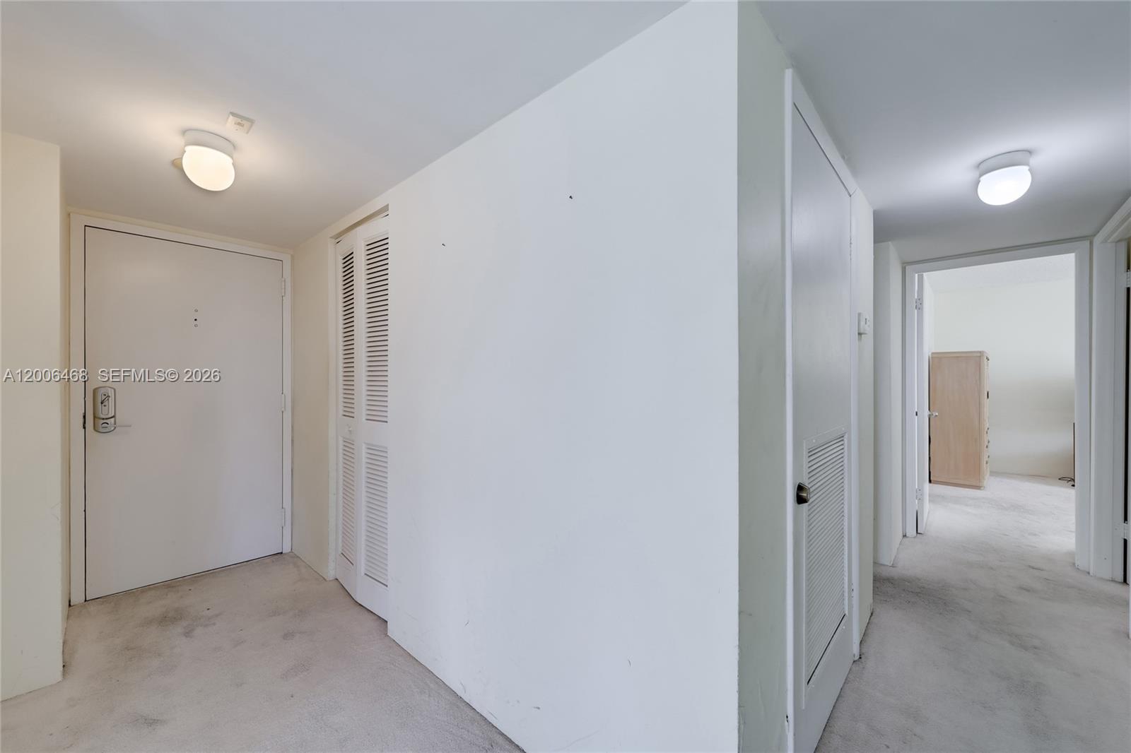 An interior hallway features white walls, carpeted floors, two ceiling lights, and several closed doors — 600 NE 36th St # 421, Miami FL 33137, MIAMI, FL