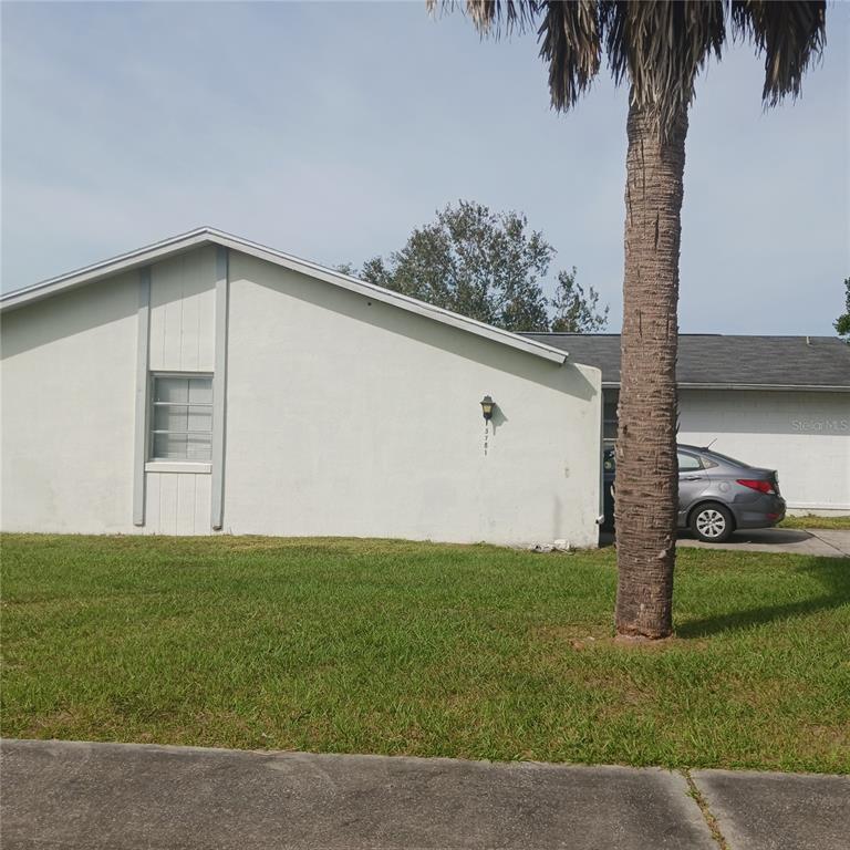 A single-story house with a light-colored exterior, a palm tree, and a parked car — 3781 SW 147TH STREET, OCALA, FL