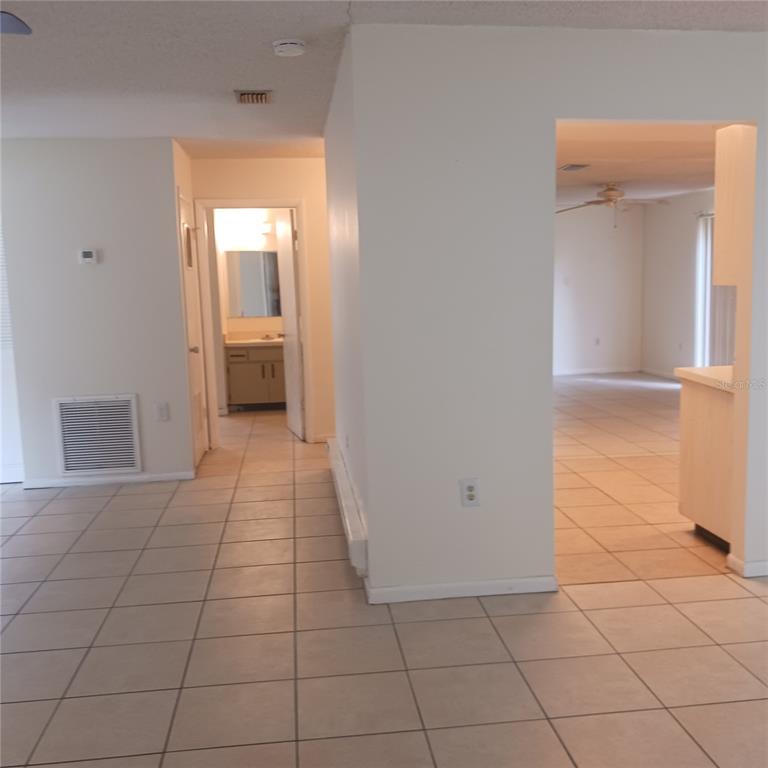 An interior view shows a tiled hallway leading to a bathroom and an adjacent living area — 3781 SW 147TH STREET, OCALA, FL