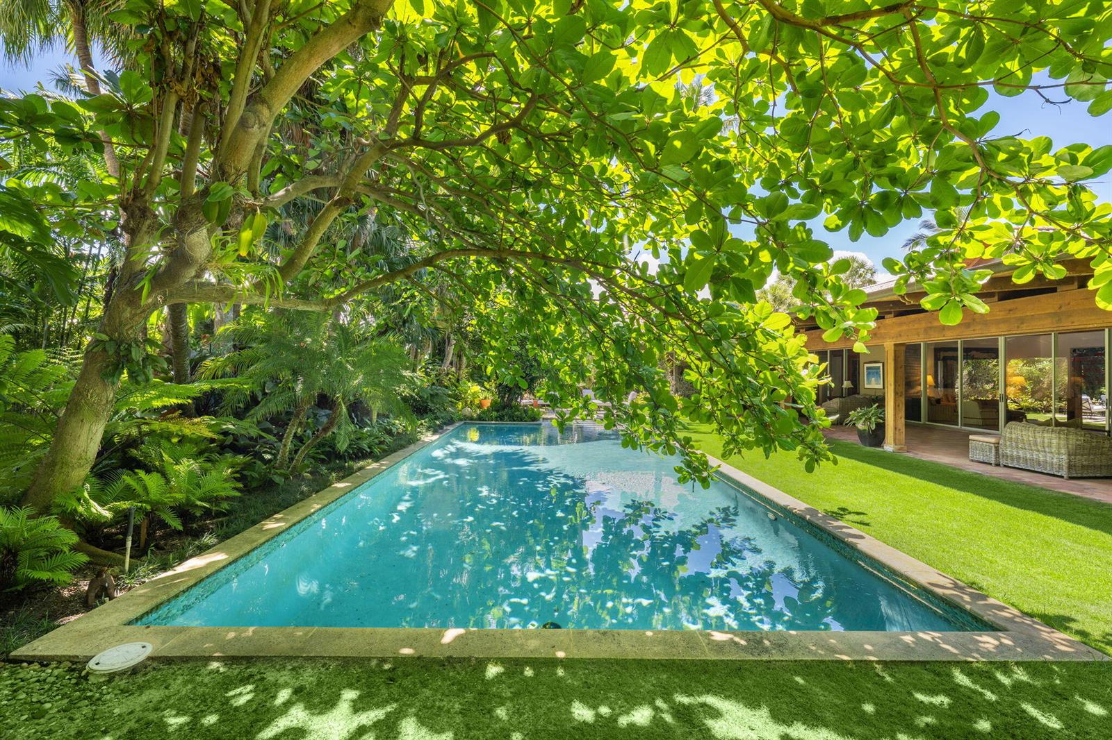 A rectangular swimming pool sits beside a house with a covered patio and lush landscaping — 6 La Costa Way, Palm Beach FL 33480, PALM BEACH, FL