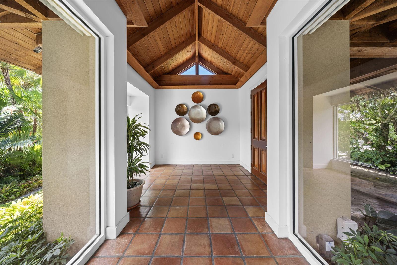 An entryway features a vaulted wood ceiling, terracotta tile floors, and decorative wall plates — 6 La Costa Way, Palm Beach FL 33480, PALM BEACH, FL