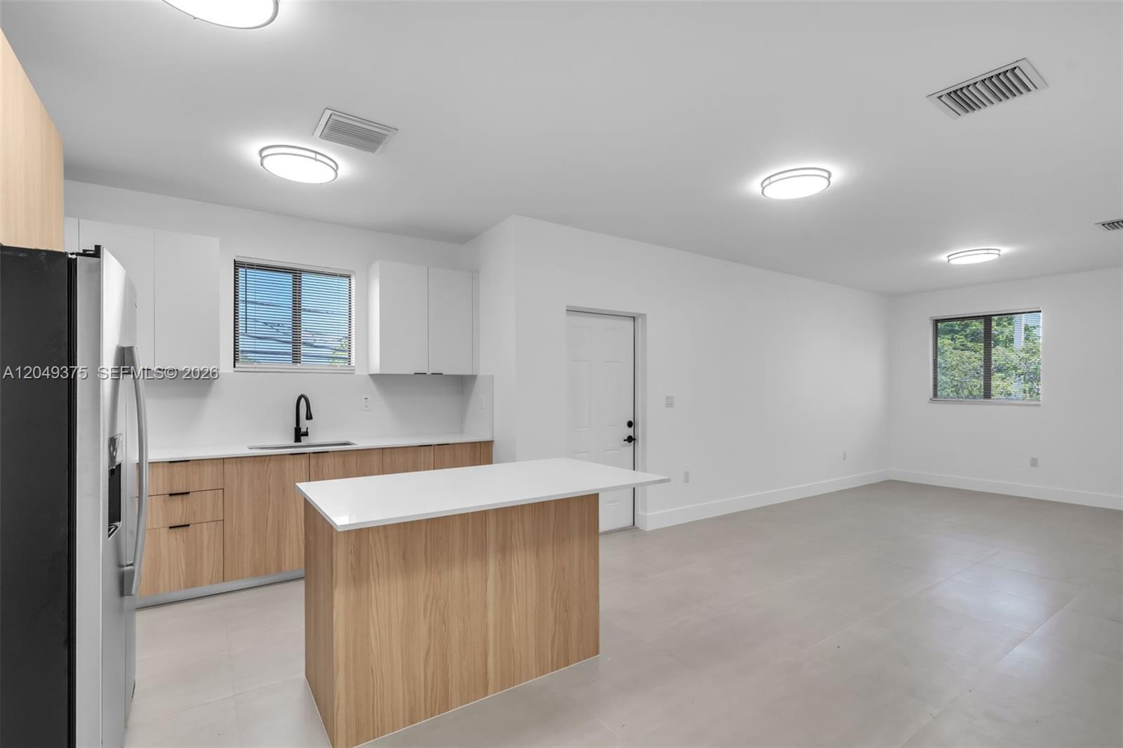 A kitchen with light wood cabinets, white countertops, and an island in an open room — 6500 NW 21st Ave # 6502, Miami FL 33147, MIAMI, FL