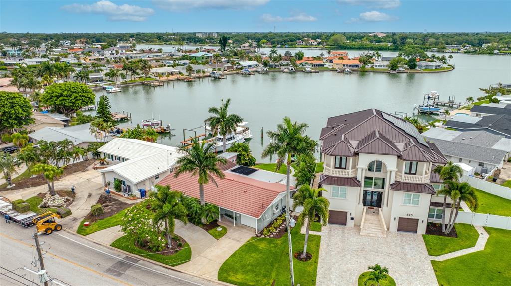 An aerial view shows two waterfront houses with palm trees and a boat dock — 560 79TH STREET S, ST PETERSBURG, FL