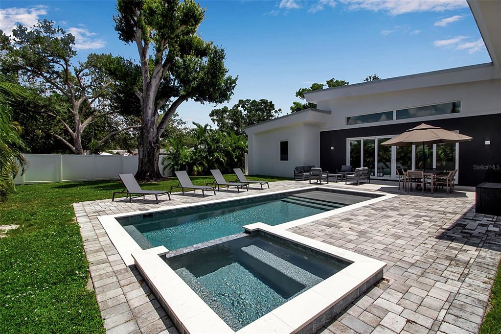 A backyard features a swimming pool with an attached spa, lounge chairs, and patio furniture — 2231 WOOD STREET, SARASOTA, FL