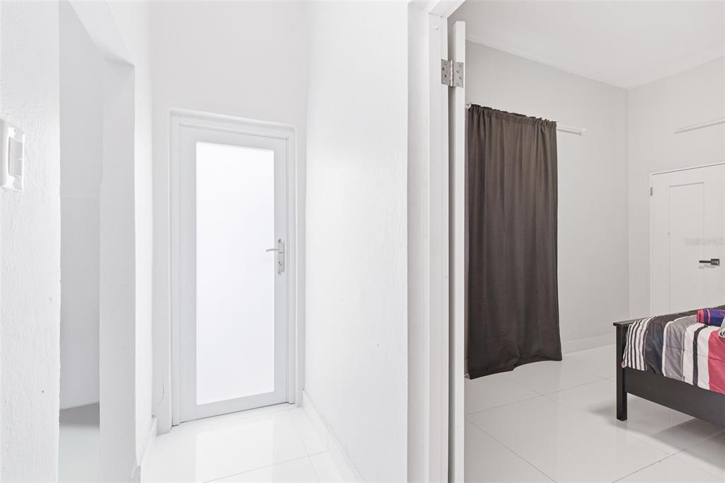A white hallway leads to a glass door, with a bedroom visible to the right — 56 CALLE F KRUG CONDADO UNIT 3, SAN JUAN, PR