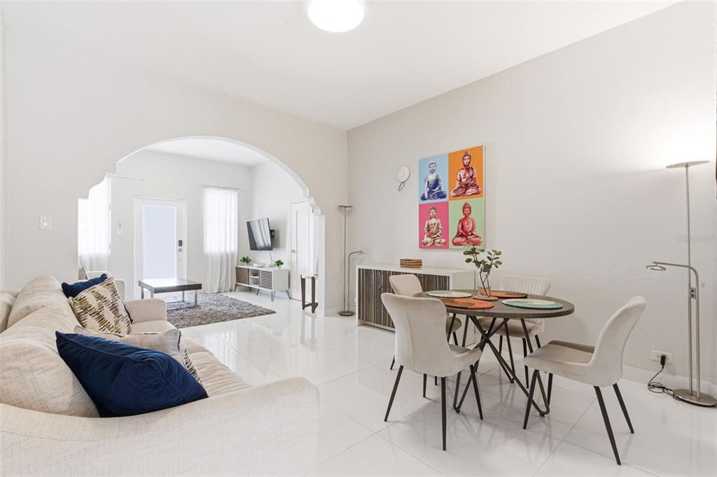 A bright, open-concept living and dining area features white tile floors and an arched entryway — 56 CALLE F KRUG CONDADO UNIT 3, SAN JUAN, PR