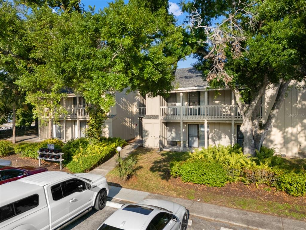 Exterior view of a two-story apartment building with balconies and surrounding trees — 2232 BAHIA VISTA STREET UNIT A1, SARASOTA, FL