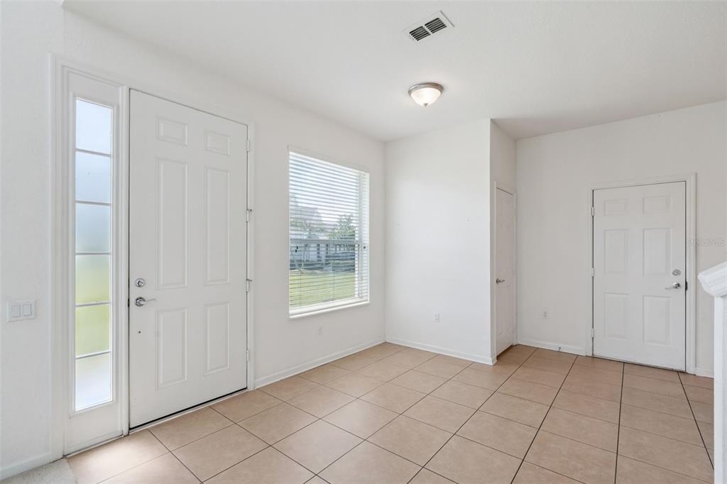 An entryway with white walls, tile flooring, a front door with sidelight, and a window — 1215 SHALLCROSS AVENUE, ORLANDO, FL