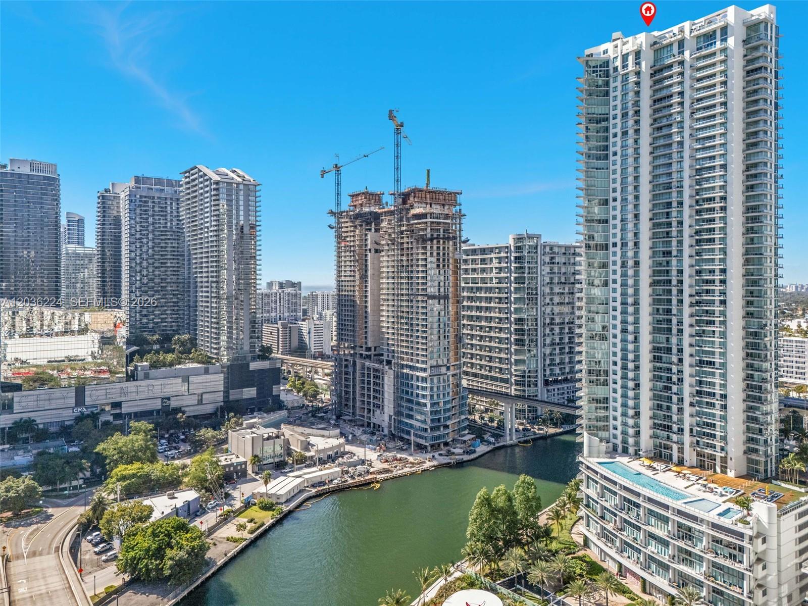 An aerial view of a city skyline featuring high-rise buildings, a river, and construction cranes — 92 SW 3rd St # 3611, Miami FL 33130, MIAMI, FL