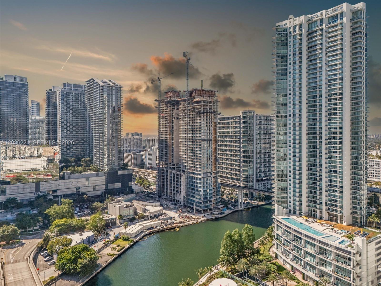An aerial view shows a canal flowing between high-rise residential buildings and a construction site — 92 SW 3rd St # 3611, Miami FL 33130, MIAMI, FL