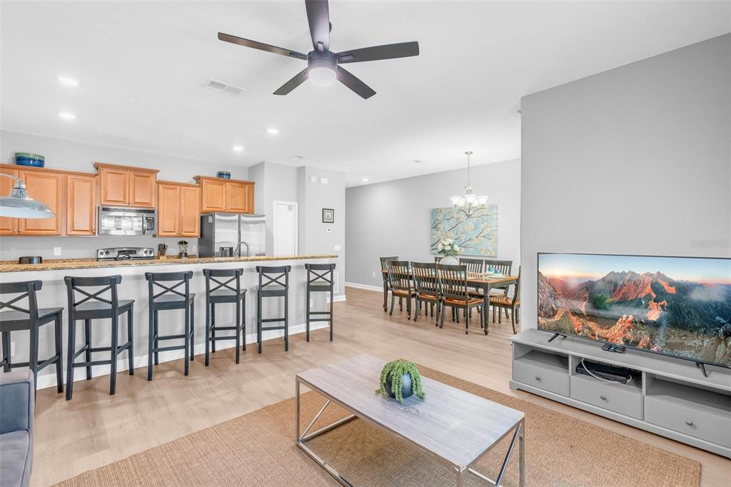 An open-concept living and dining area features a kitchen island with bar stools — 2903 BANANA PALM DRIVE, KISSIMMEE, FL