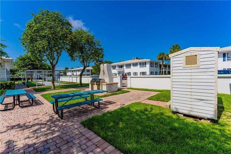 An outdoor patio area features picnic tables, a brick grill, and a small storage shed — FORT LAUDERDALE, FL