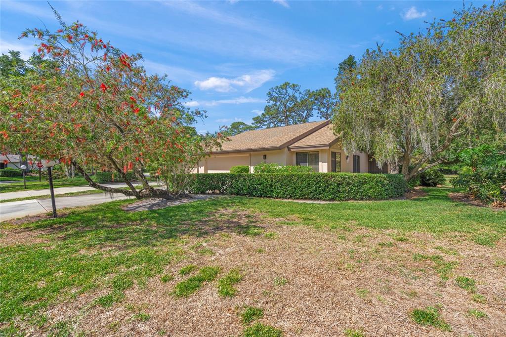 A single-story house with a tan exterior, a garage, and a manicured hedge in front — 4688 OAK HOLLOW DRIVE UNIT 25, SARASOTA, FL