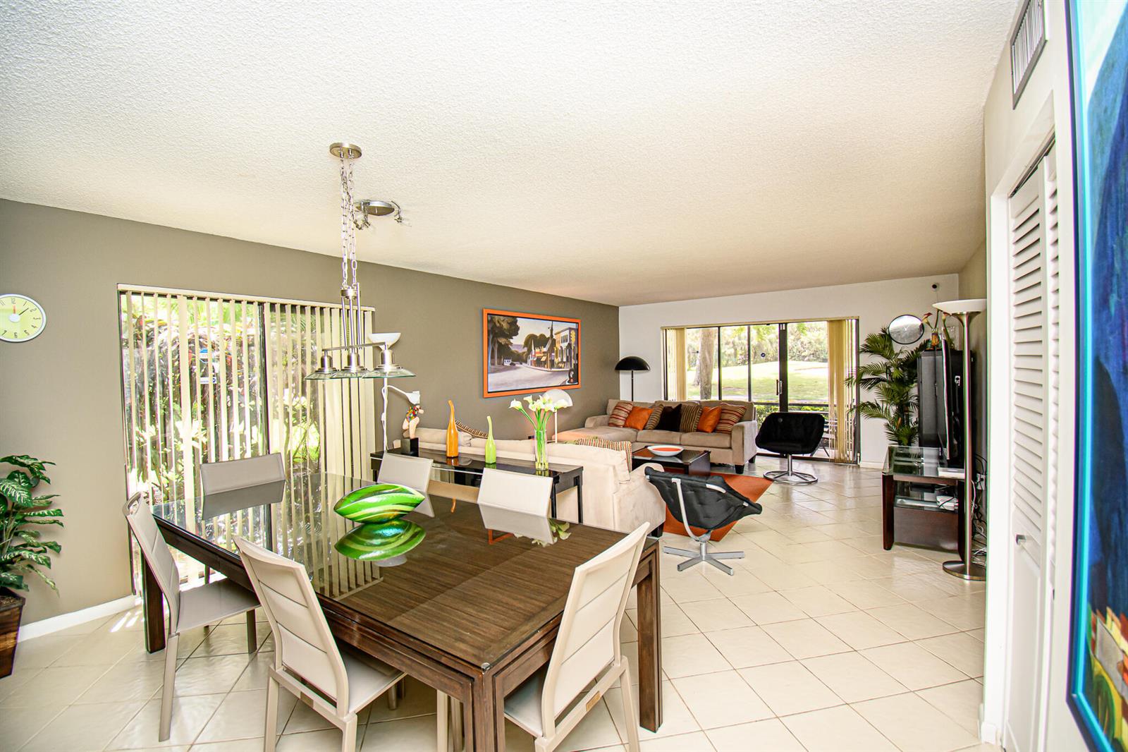 A dining area and living room with tile floors, sliding glass doors, and modern furniture — 8334 Cypress Lane # 1a, Boca Raton FL 33433, BOCA RATON, FL