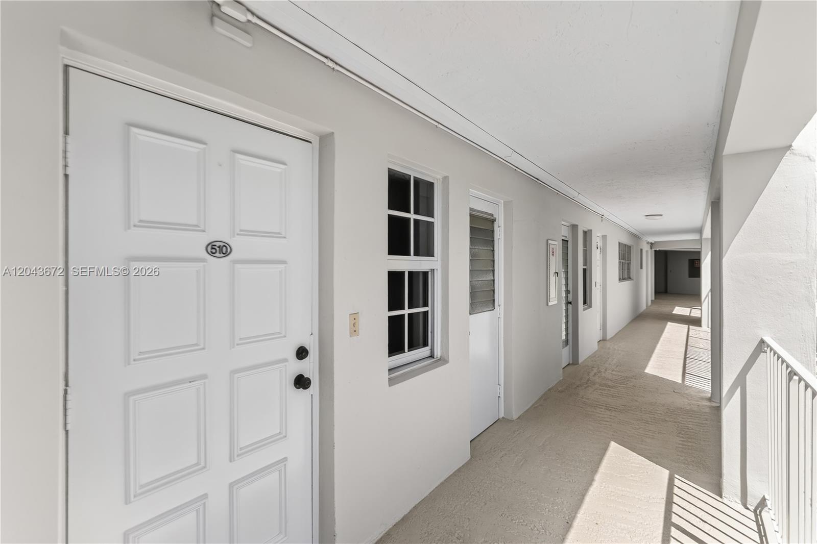 An exterior hallway shows white doors with unit numbers and windows along a concrete walkway — 3010 N Course Dr # 510, Pompano Beach FL 33069, POMPANO BEACH, FL