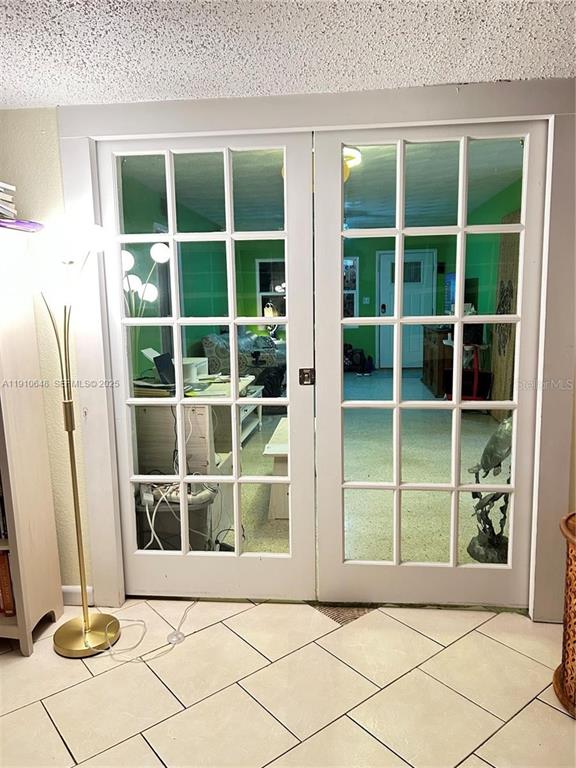 A set of white French doors with glass panes opens into a room with green walls — 118 BOUGAINVILLEA DRIVE, ROCKLEDGE, FL