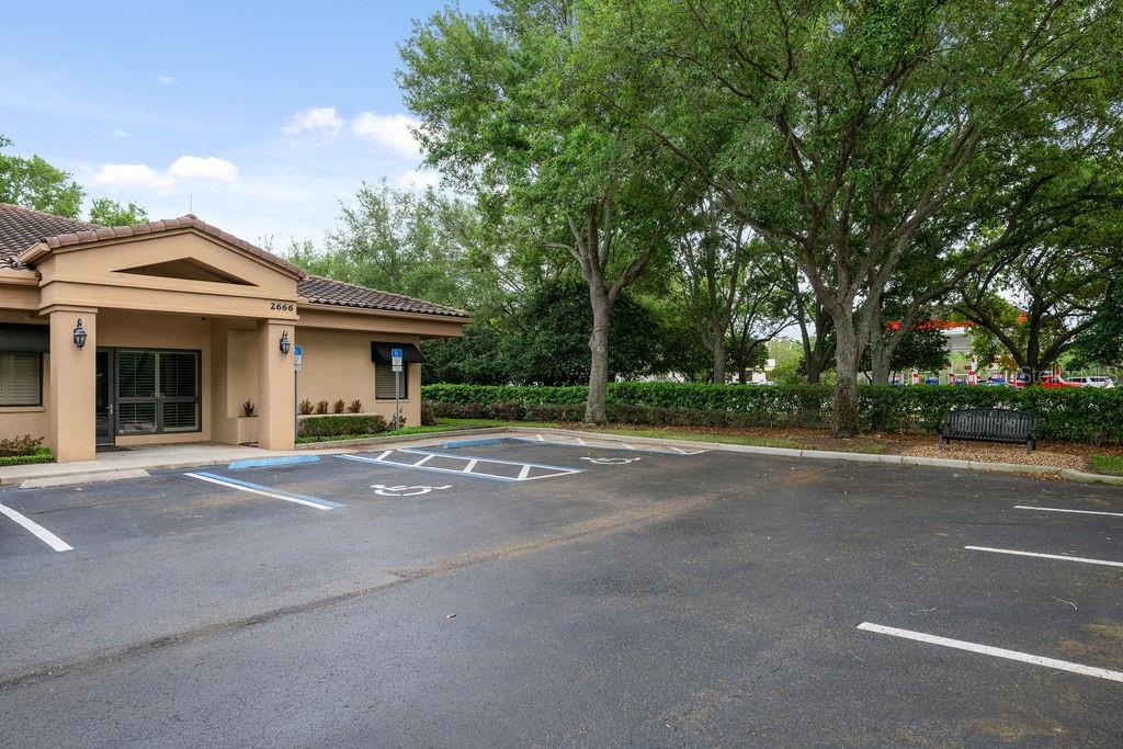 A tan commercial building exterior features a parking lot with designated handicap spaces — 2666 MAGUIRE ROAD, OCOEE, FL
