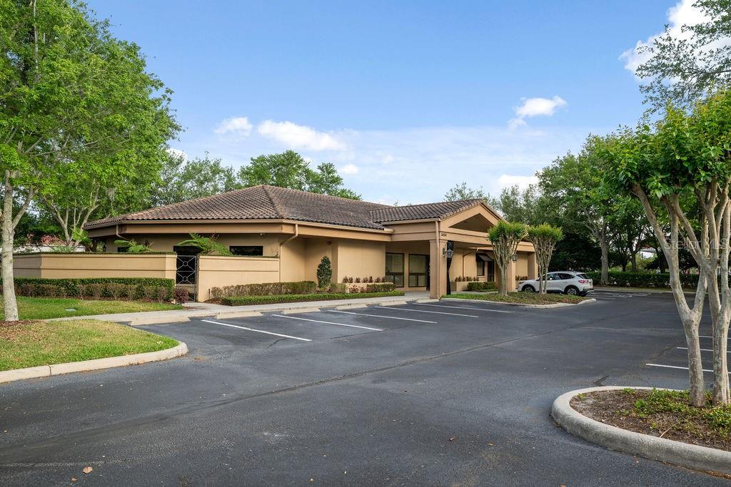 A tan, single-story commercial building with a tiled roof sits behind a paved parking lot — 2666 MAGUIRE ROAD, OCOEE, FL