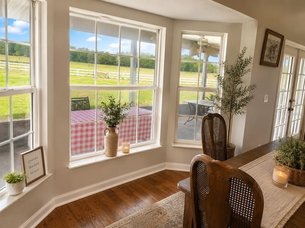 A dining area features a bay window overlooking a fenced pasture and hardwood floors — 505 DEEN STILL ROAD, DAVENPORT, FL