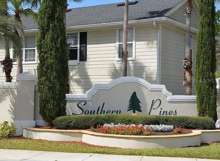 A beige building stands behind a curved stone sign labeled Southern Pines with landscaping — 1301 EASTERN PECAN PLACE UNIT 208, WINTER GARDEN, FL